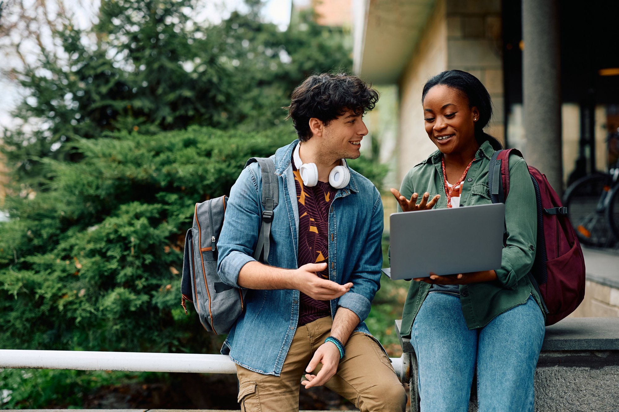 Happy students looking at laptop satisfied by a successful and easy admissions process